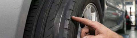 En tekniker fra Fagdekk/Point S som undersøker ujevn slitasje på et bildekk